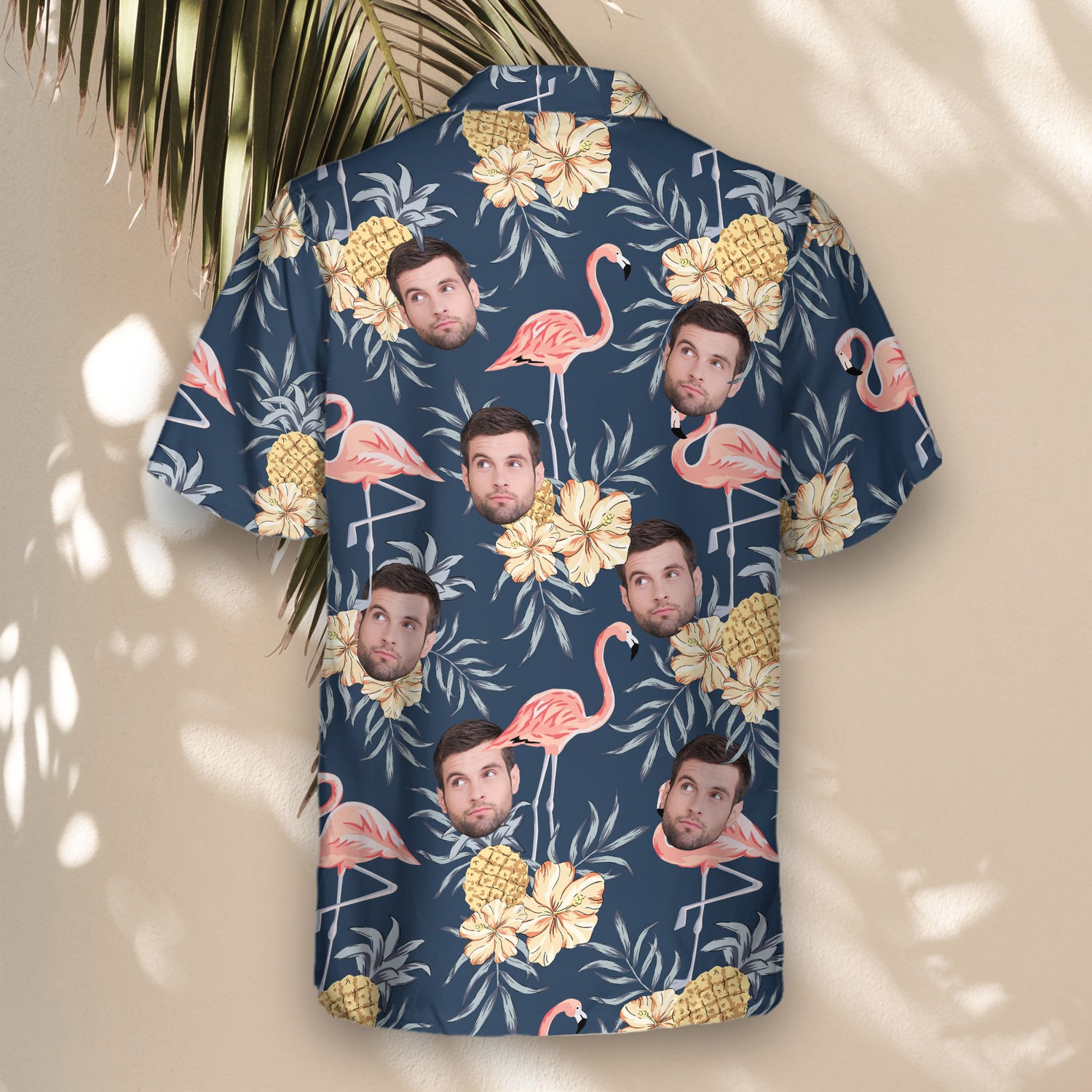Custom Hawaiian shirts with faces on them, showcasing pink flamingos, hibiscus flowers, and pineapples on a navy background, offering a colorful tropical style.