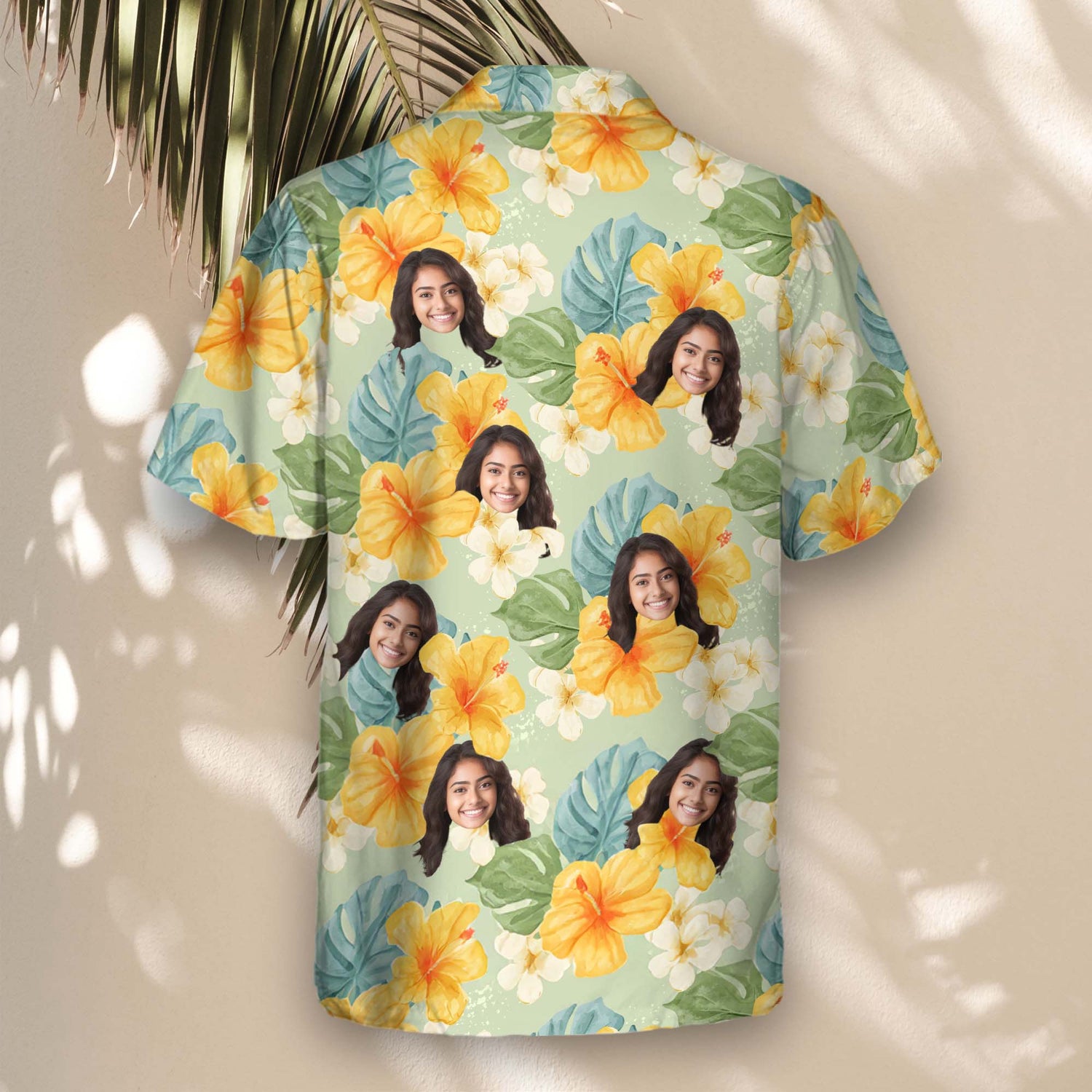 Vibrant custom Hawaiian shirts with yellow hibiscus and tropical plants against a light green background. Add faces on them for a tropical feel.